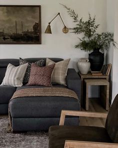 a living room filled with lots of furniture next to a wall mounted painting on the wall