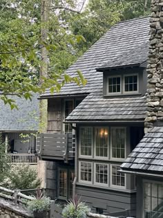 a house with stone and slate roofing in the woods