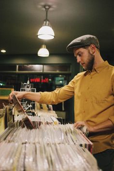 a man in a yellow shirt is looking at records