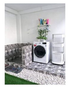 a washer and dryer in a small room with grass on the ground next to it