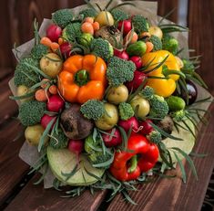 a bouquet of fresh vegetables sitting on top of a wooden table