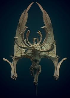 a sculpture of a demon with horns and wings on it's head, against a dark background