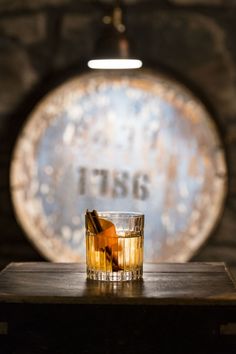 a glass filled with liquid sitting on top of a wooden table