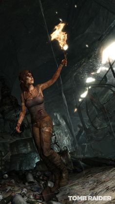 a woman holding a torch in her hand and standing next to a pile of rubble