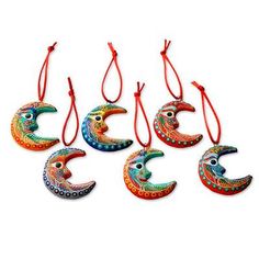 six colorful ceramic moon ornaments hanging from red string