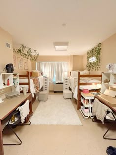 a room with bunk beds and desks in it