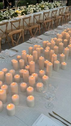 many lit candles are on the table at a wedding