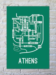 a green poster with the words athen's in white on a brick wall