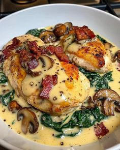 a white plate topped with chicken covered in cheese sauce and mushrooms on top of spinach