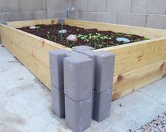 a planter filled with concrete blocks sitting on top of a cement block garden bed