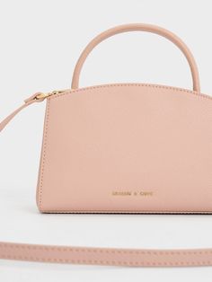 This product is made with at least 20% sustainable materials by weight. CHARLES & KEITH uses recycled, degradable, organic, and water-based materials in our eco-conscious collection. This soft, blush-pink iteration of our Aubrielle top handle bag is the ultimate feminine bag of choice for all occasions. Featuring a streamlined and classic silhouette complete with rounded corners and soft curved lines, this piece strikes the perfect balance between casual and formal. The sleek gold-toned hardware adds a hint of polish to the design. On days when you are looking to go hands-free, simply attach the shoulder strap. Laptop Handbags, Laptop Handbag, Buckle Top, Office Bag, Curved Lines, Charles Keith, Work Travel, Handle Bag, Pink Bag