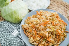 a plate with rice, carrots and cabbage on it