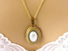 "Gold Plated Brass Locket Necklace: Carry photos of loved ones close to your heart with this Victorian-style gold plated brass locket embellished with a faux pearlcabochon. The working locket can hold 2 photos. I can make it with a gold plated chain in a length of your choice. Pendant Height: 1.6 inches Length - choose from 16 to 36 inches I can also make this with a silver plated locket, or with a faceted Bermuda Blue acrylic cabochon, as shown in the last photo, with either a silver plated or Dainty Oval Locket Necklace For Wedding, Elegant Gold Locket Necklace For Wedding Gift, Vintage Adjustable Locket Necklace For Wedding, Classic Locket Jewelry For Wedding, Classic Locket Necklace For Wedding, Classic Wedding Locket Jewelry, Adjustable Gold Locket Necklace For Wedding, Delicate Gold Locket Necklace For Wedding, Elegant Locket Necklace For Wedding Gift