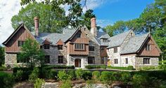 a large stone house surrounded by trees and bushes