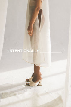 a woman standing in front of a white curtain with the words internationally written on it