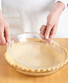 a person in an apron is making pie crusts on top of a wooden table