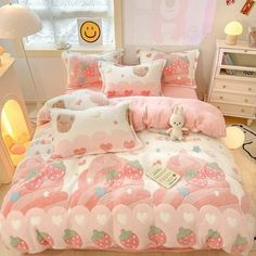 a bed with pink and white strawberry themed comforter set on top of it in a bedroom