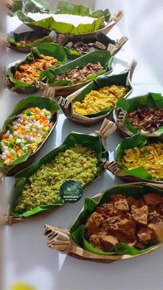 a table topped with lots of different types of food on leaf shaped trays filled with meat and veggies