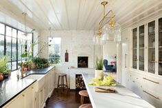 a kitchen with white cabinets and counter tops next to an open fire place in the wall