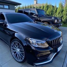 a black mercedes s - class parked in front of a house