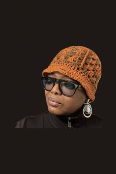 a woman wearing sunglasses and a crocheted hat with ear rings on her head