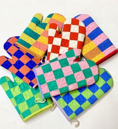 oven mitts and gloves made out of legos on a white surface with one hand in the shape of a checkerboard pattern