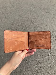 a person holding an empty wallet in their hand on the ground with no one around it