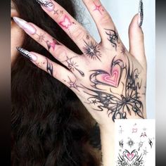 a woman's hand with tattoos on it and her nails in the shape of hearts