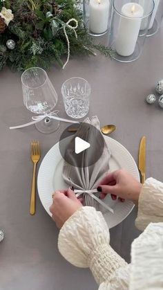 a woman is decorating a table with silverware