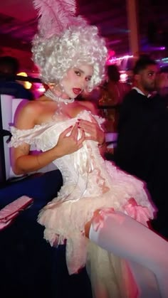 a woman dressed in white and pink posing for the camera