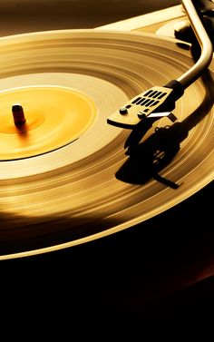 an old record player is spinning the vinyl on it's turntable with yellow and black colors