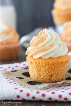 cupcakes with white frosting sitting on a napkin