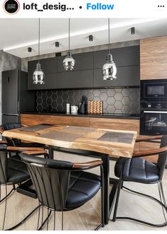 a modern kitchen with black cabinets and wooden table surrounded by chairs that are up against the wall