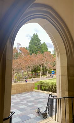 an archway leading into a park with trees in the background