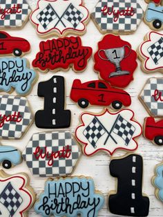 birthday cookies decorated with racing cars and checkered flags are displayed on a white table