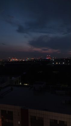 the city skyline is lit up at night from an apartment building in the foreground