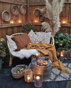 an outdoor area with candles, pillows and blankets