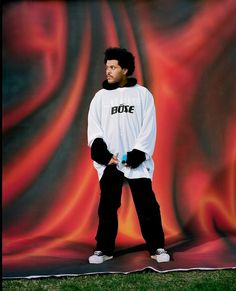 a man standing in front of a red and black backdrop wearing a white shirt with the word duke on it