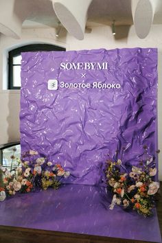 some flowers are sitting on a purple table and there is a sign that says sombrymi