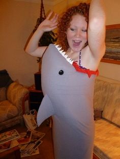 a woman in a shark costume holding her arms up