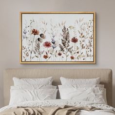 a bed with white linens and flowers on the headboard is shown in front of a framed art piece