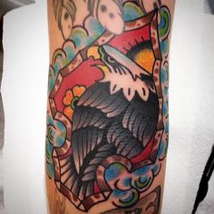 an eagle tattoo on the leg of a person's arm, with other tattoos around it