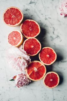 grapefruits and peonies on a marble surface