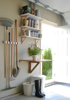 a shelf filled with gardening tools next to a window