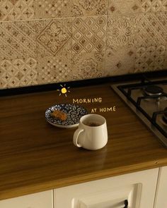 a cup of coffee sitting on top of a counter next to a plate with food