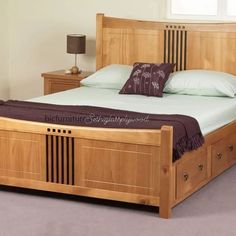 a wooden bed frame with drawers underneath the headboard and foot board, in a bedroom