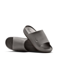 It's all in the name when it comes to these slides by Nike. Slip into a calm state when you wear the Nike Calm minimalist slides with maximum cushioning. The contoured foam is seamlessly created from one piece and cradles your feet to keep them in place. Even better—this slide is quick-drying, making water-related activities even more relaxing. You get all of the style with no extra effort on your end. It's time to slip into your Calm. Allover print. Comfortable slip-on slides. Soft yet responsi Nike Non-slip Slides, Comfortable Nike Slide Flip Flops, Nike Slide Flip Flops With Cushioned Footbed, Nike Open Toe Slides With Textured Footbed, Nike Non-slip Slip-on Slides, Nike Slides Comfortable Non-slip, Comfortable Nike Slip-on Slides, Non-slip Gray Synthetic Slides, Synthetic Slides With Gel Cushioning