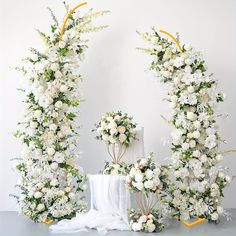 white flowers and greenery are arranged in the shape of letters