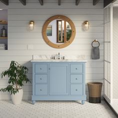 a bathroom with a sink, mirror and potted plant on the floor in front of it