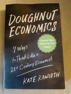 a blackboard with the title doughnut economics on it and an image of a man writing